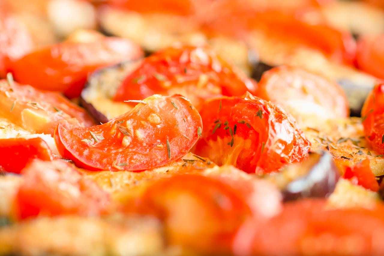 Vibrant close-up of roasted tomatoes and vegetables with herbs, perfect for food blogs.